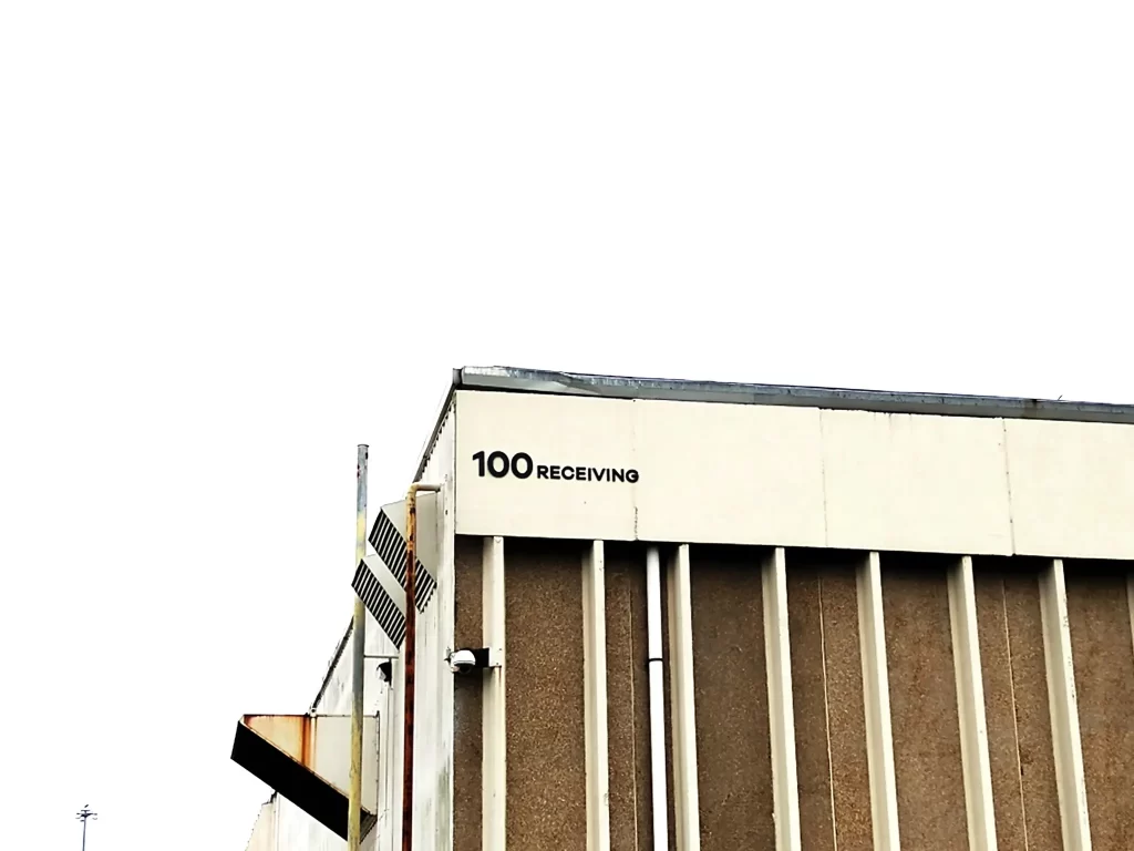 Exterior cut vinyl graphics displaying "100 RECEIVING" on a warehouse building in Chamblee, GA.