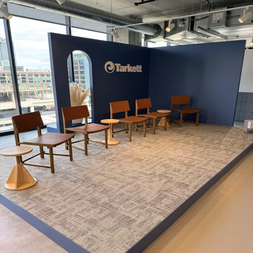 Custom fabricated stage with Tarkett logo in dimensional cut vinyl, featuring Tarkett flooring for the LEAP NeoConn Design Days - Tailored services by 360CSG.