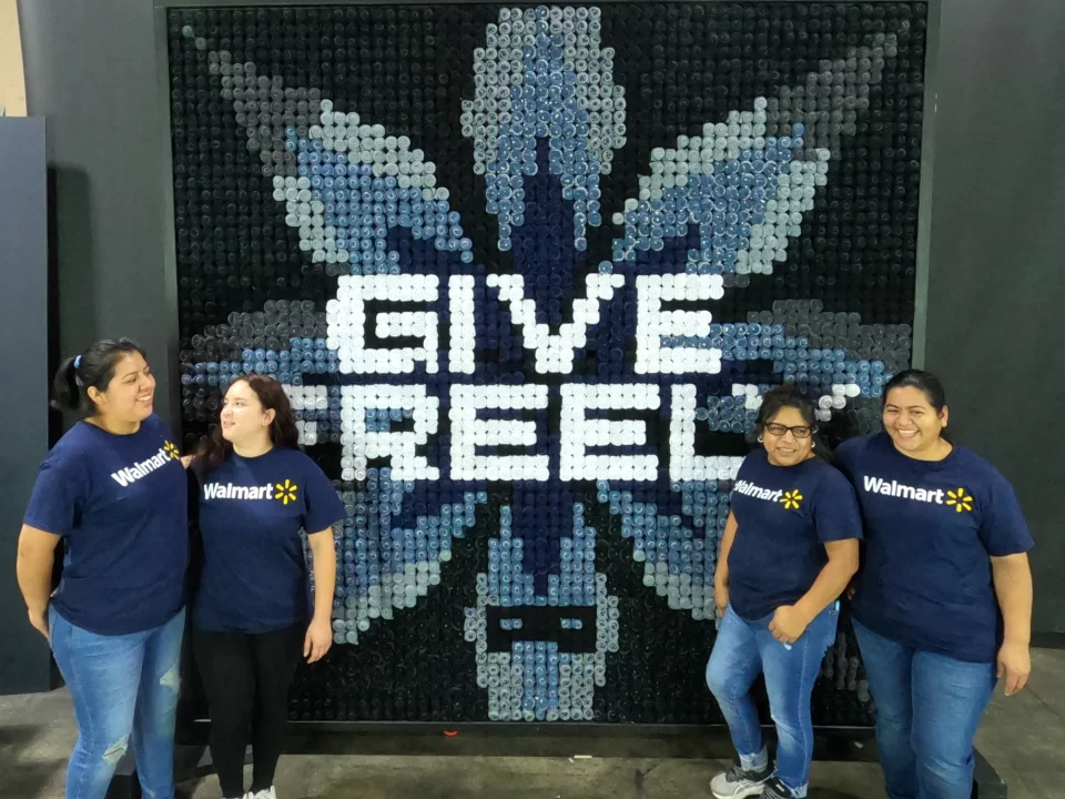 Walmart Employees with Custom 'Give Freely' Display | 360CSG Walmart employees in front of custom 'Give Freely' display made from individual socks, part of experiential marketing by 360CSG in Alpharetta, GA